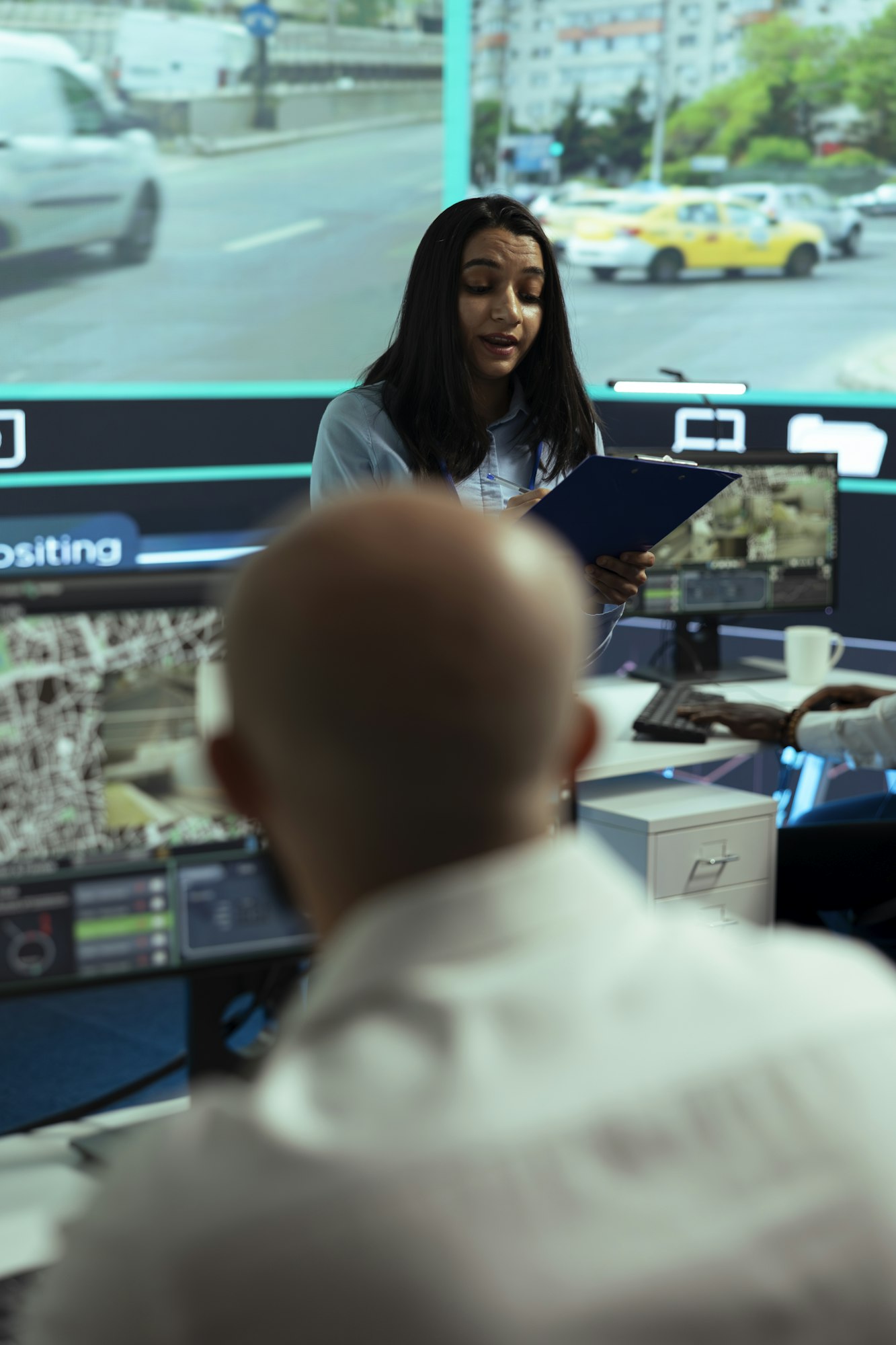 Traffic-control analyst briefing team in real-time monitoring centre