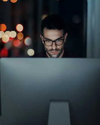 Developer analysing tolling data on desktop at night